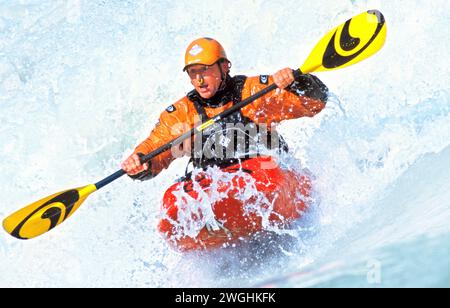 Kayaker in a wave of the Isar at the Wittelsbacher Bridge, Munich, Germany Stock Photo