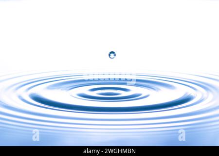 a drop causes circular waves on the water surface Stock Photo