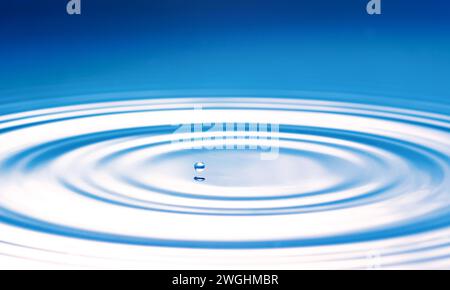 a drop causes circular waves on the water surface Stock Photo