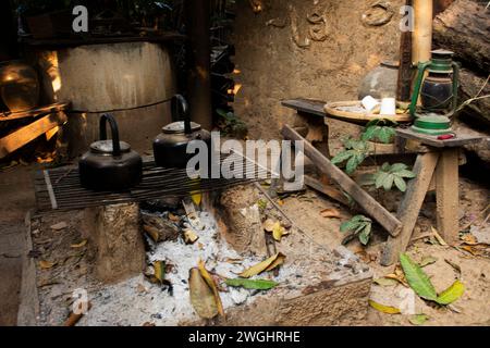 Vintage retro aluminium kettle pot on antique campfire stove for local thai people cooking boiling water tea at outdoor of Sao Hai bazaar and farmers Stock Photo