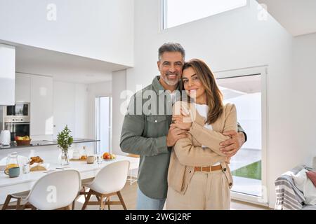 Happy middle aged mature couple hugging standing at home. Portrait. Stock Photo