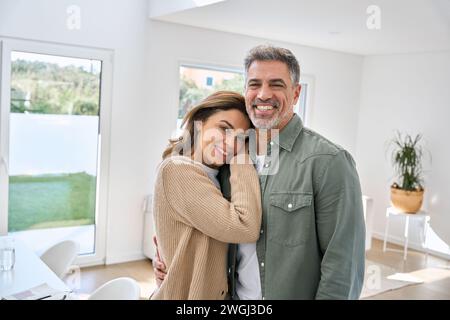 Smiling middle aged mature couple embracing standing at home. Portrait. Stock Photo