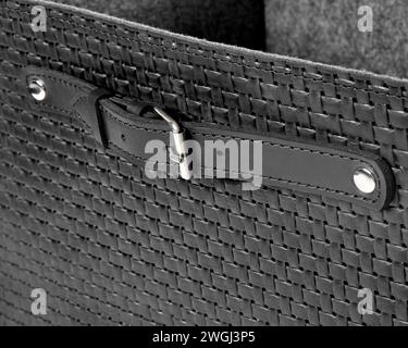 Closeup of black leather woven box with strap handle on rivets with buckle Stock Photo