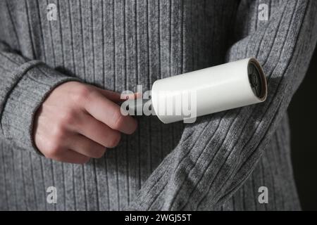 Hair remover roller. Woman using reusable clothes lint roller cleaner. Stock Photo