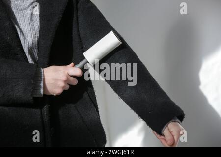 Hair remover roller. Woman using reusable clothes lint roller cleaner. Stock Photo