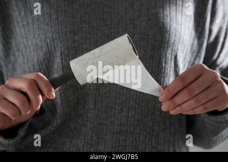 Hair remover roller. Woman using reusable clothes lint roller cleaner. Stock Photo