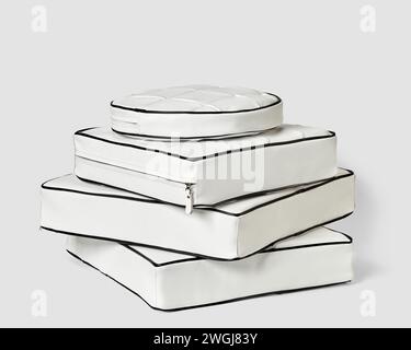 Stack of white leather floor cushions in various shapes Stock Photo