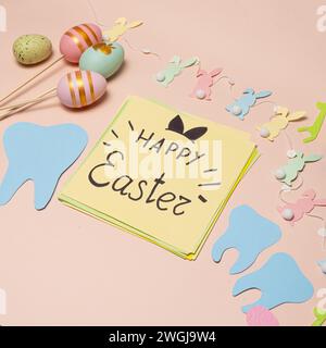 Greeting card for dentistry happy Easter text, tooth, painted eggs and bunnies top view. Stock Photo
