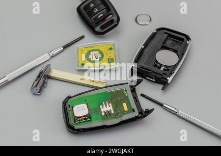 Broken Or Damaged Car Key Fob And New Remote Vehicle Key On Grey Background. Repair Of Broken Or Damaged Remote Key Stock Photo