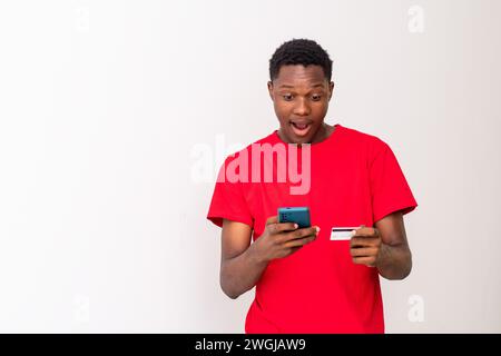young black man using his phone and credit card Stock Photo