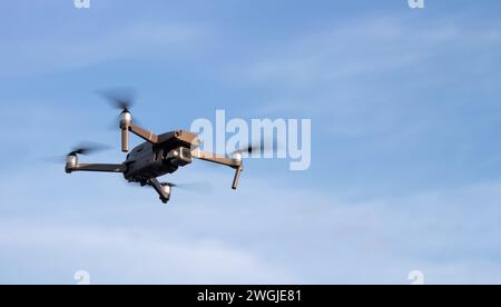 Drone or quadcopter in the sky at sunset. Unmanned vehicle for photo and video shooting. Stock Photo
