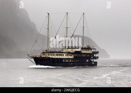 Fiordland Navigator cruise ship making way on a rainy day in Doubtful Sound / Patea, Fiordland /Te Rua-o-te-Moko, New Zealand / Aotearoa, South Island Stock Photo