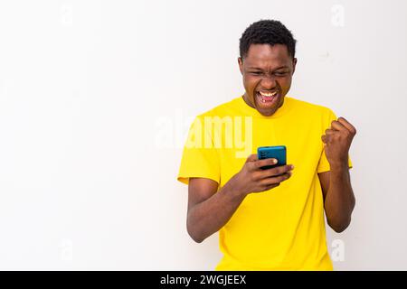 excited young black man checking his smartphone Stock Photo
