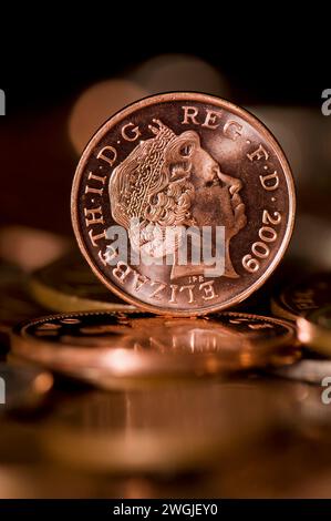Studio shot of a one penny piece with Queen Elizabeth head on in Sterling currency standing upright Stock Photo