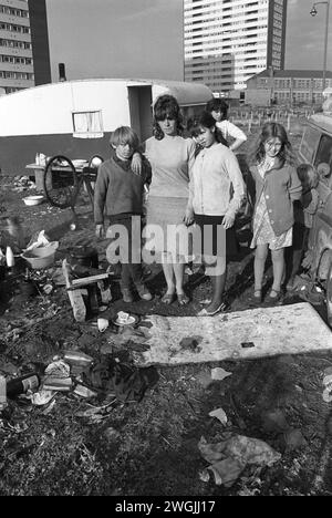Irish Tinkers 1960s UK. Gypsy Irish travellers, family group, mother and four children, their caravan and tower blocks on inner city wasteland that will soon to be developed. Balsall Heath, Birmingham, England March 1968. HOMER SYKES Stock Photo