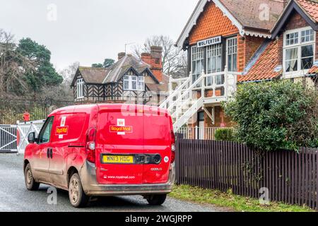 A Royal Mail post van next to the old railway signal box in the village of Wolferton, Norfolk. Stock Photo