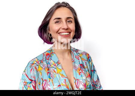 Dark-haired woman smiles a wide smile, showing perfect teeth. Blouse with deep neckline. Stock Photo