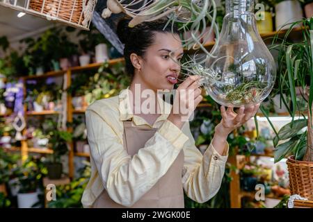 Beautiful woman owner standing in own plant shop and care of succulent. African American females business partners working garden store. Business Stock Photo