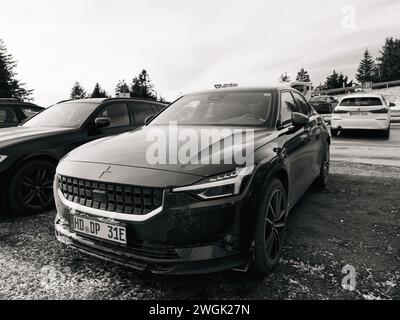 Germany - Jan 21, 2024: Black electric Polestar SUV with distinctive grille parked on snowy ground among other vehicles Stock Photo