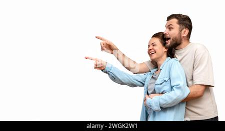 Isolated happy heterosexual couple pointing fingers on promotional product. Stock Photo