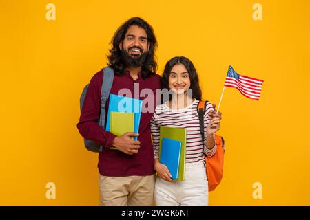 Happy indian man and woman students showing flag of US Stock Photo