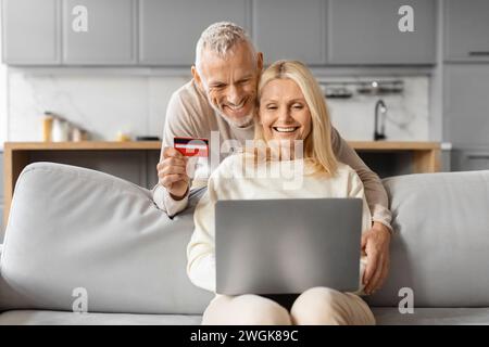 Excited senior european couple buying weekend trip on Internet Stock Photo