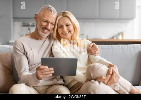 Happy Senior Couple Using Digital Tablet Together Browsing Internet Stock Photo