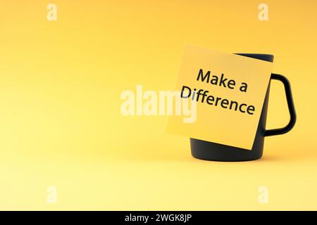 Sticky note on coffee cup with text Make a difference Stock Photo