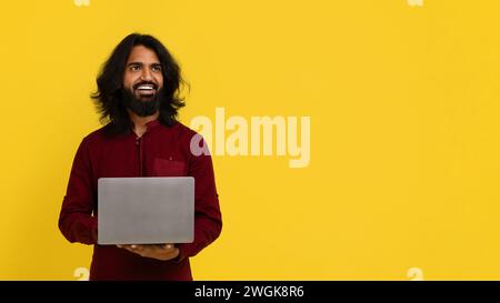 Happy attractive stylish young indian guy using modern notebook Stock Photo