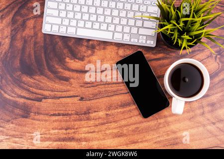 Wooden desk with coffee, smartphone  and computer keyboard flat lay Stock Photo