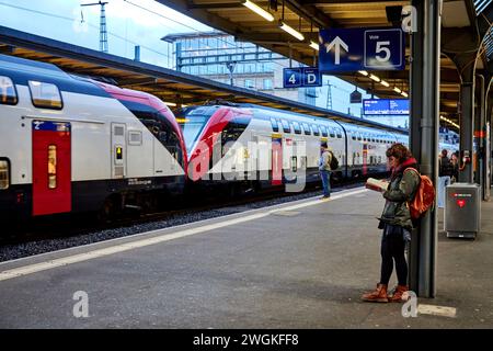 Geneva city in Switzerland Gare de Genève train station passenger reading a book waiting for her train Stock Photo