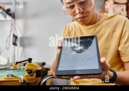 blurred asian technician in goggles making technical expertise on digital tablet with blank screen Stock Photo