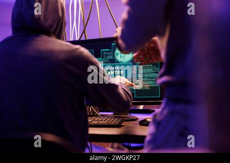 Criminals hacking computer network system successfully and getting access granted message on screen. Hackers breaking into server to steal valuable information while doing illegal activities Stock Photo