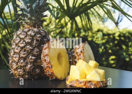pineapple (Ananas comosus, Ananas sativus), whole fruit, pineapple slices and pineapple chunks on a table, fresh fruits Stock Photo