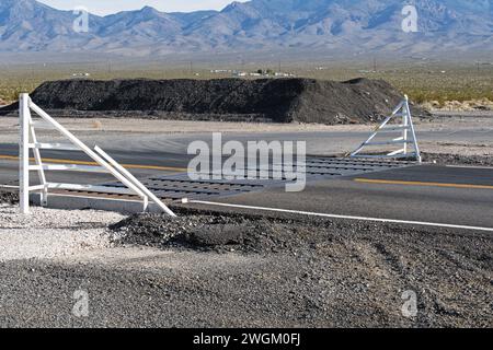 cattle guard and fence on paved road in the desert of Nevada Stock Photo