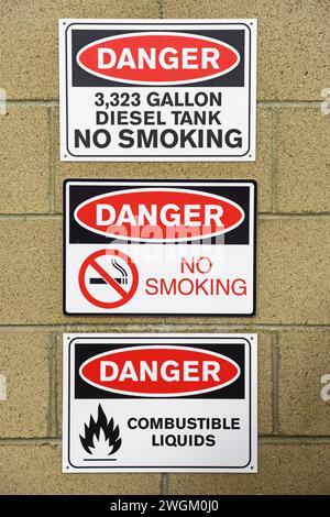 danger signs for deisel fuel no smoking and combustible liquids on block wall Stock Photo
