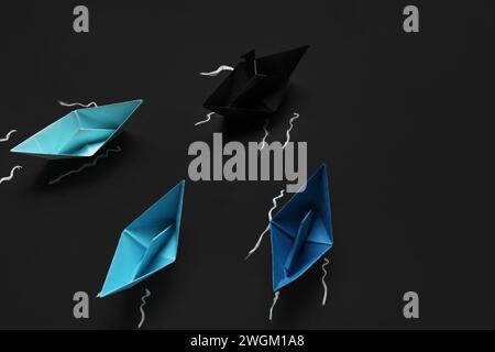 Colorful origami boats and drawn waves on black chalkboard Stock Photo