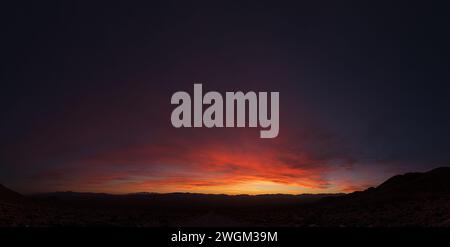 dramatic desert sunset in Nevada with a dirt road heading away towards distant mountains Stock Photo
