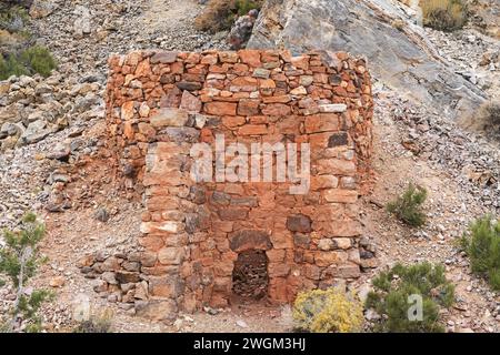 old stone cement of charcoal kiln in the Nevada desert with limestone outcrop behind it Stock Photo
