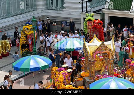 The Erawan shrine is a popular tourist destination in Bangkok & visitors come here to pray for good fortune & protection, seen with lion dance troupe Stock Photo