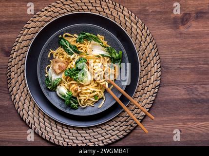 A dish of longevity noodles with spicy pork and veggies, ready for eating. Stock Photo