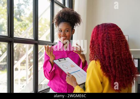 Two businesswoman African American working together talking about a business project. team of females executives meeting work in office Stock Photo