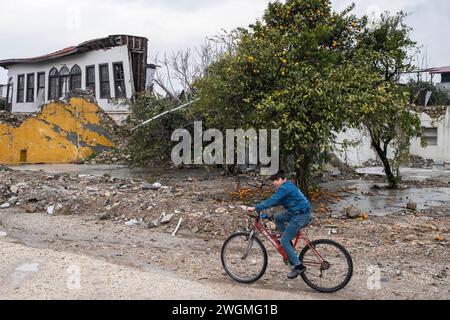 Hatay, Turkey. 05th Feb, 2024. A child rides his bike through houses destroyed in the earthquake. On February 6, 2023, a magnitude 7.8 earthquake occurred in southern Turkey, followed by another magnitude 7.5 tremor just after noon. More than 50,000 people lost their lives in the earthquake that caused great destruction in 11 cities of Turkey. Credit: SOPA Images Limited/Alamy Live News Stock Photo