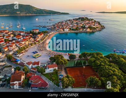 Primosten, Croatia - Aerial view of Primosten peninsula with public beach, tennis courts, St. George's Church and old town on a sunny summer afternoon Stock Photo