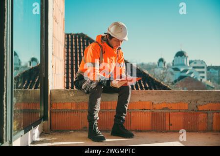 Architect and construction engineer making notes and remarks during building site inspection, selective focus Stock Photo