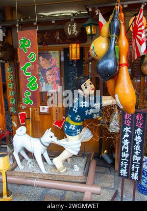 An Okonomiyaki restaurant called Issen Yoshoku in Gion, Kyoto, Japan with a dog chasing a boy thief and biting on his trousers. Stock Photo