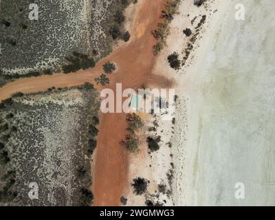 An aerial view of a red road next to dry salt pan Lake Ninan in Western Australia Stock Photo