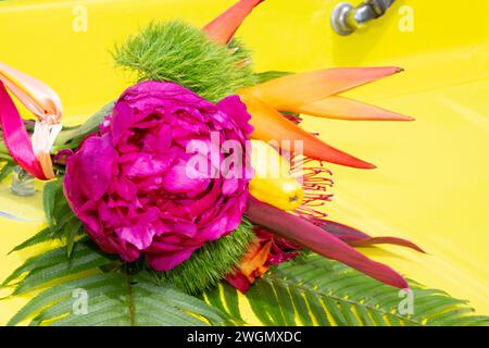 yellow vintage wedding car decorated with colorful flowers on a sunny day Stock Photo