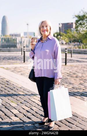 senior woman with shopping bags and a coffee Stock Photo