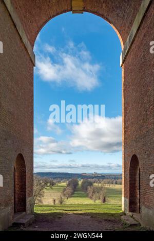 View through the single arch of Bellmount Tower down the tree lined avenue to Belton House, Grantham, Lincolnshire, England, UK Stock Photo